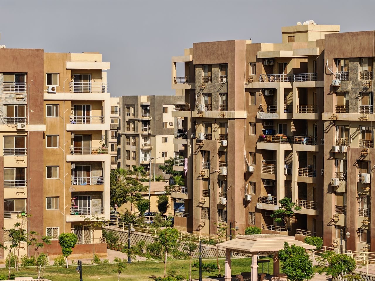 View of multiple modern apartment buildings in a sunny urban environment.