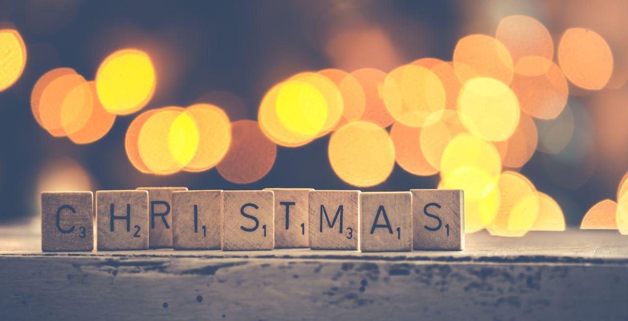 Christmas spelled with Scrabble tiles against a warm bokeh background, perfect for holiday themes.
